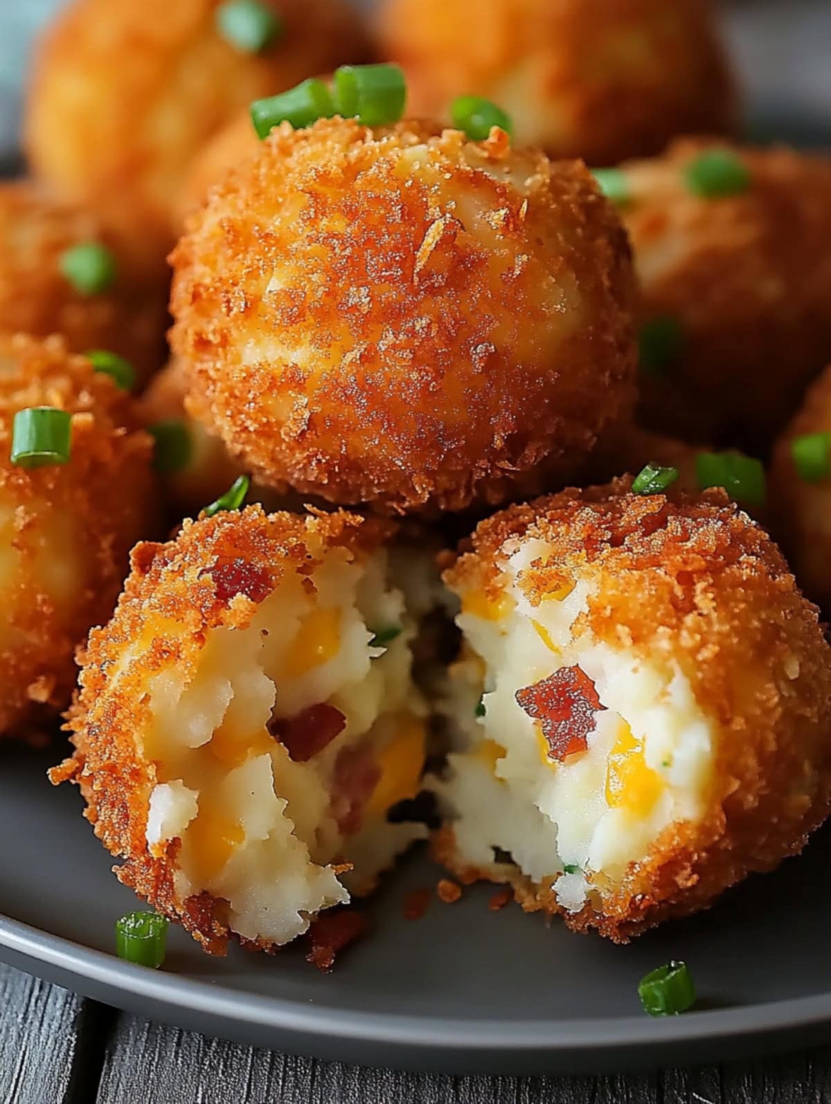 Bunch of loaded mashed potato bites served in a gray plate.