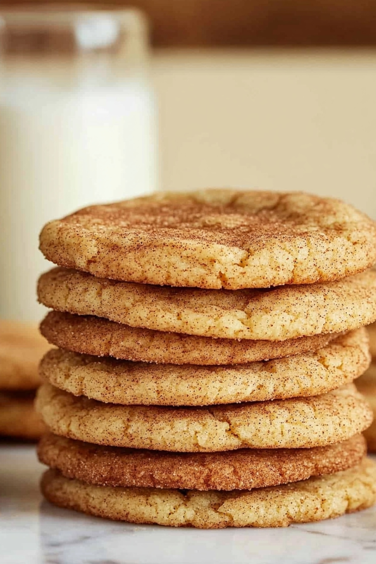 Soft and chewy maple snickerdoodles stacked on a marble table