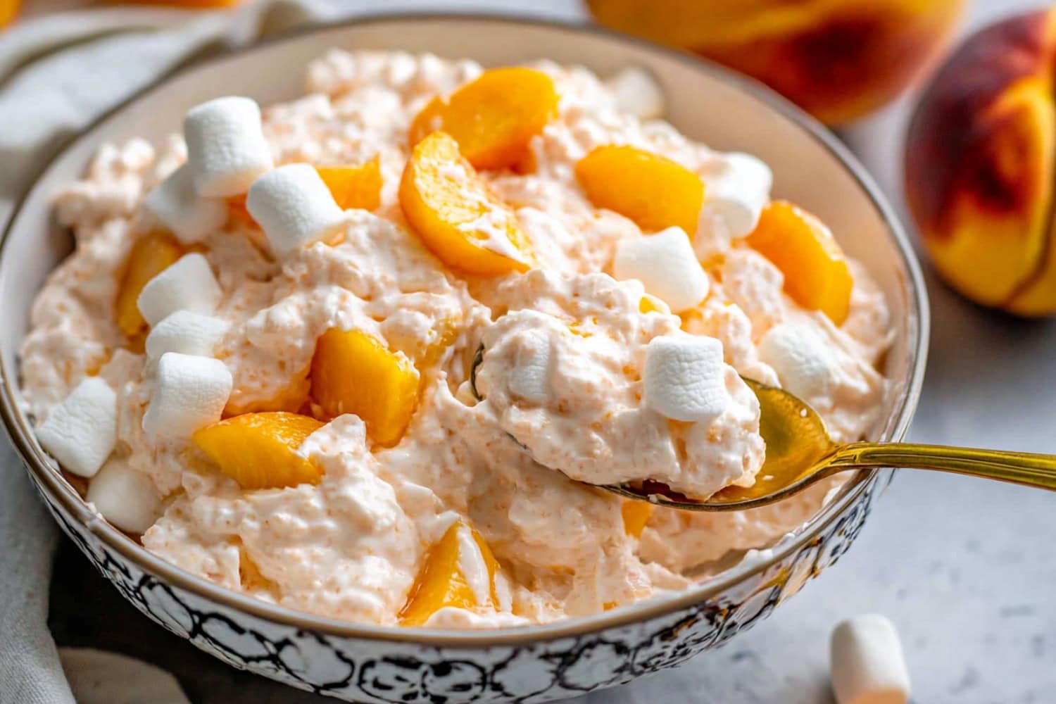 Creamy and fluffy peach salad with mini marshmallows in a bowl.