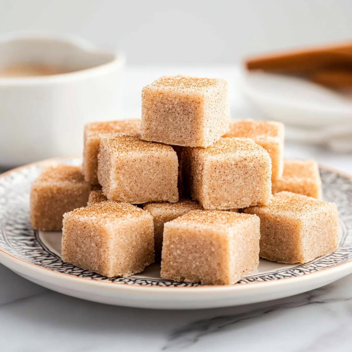 Snickerdoodle fudge squares stacked on a plate.