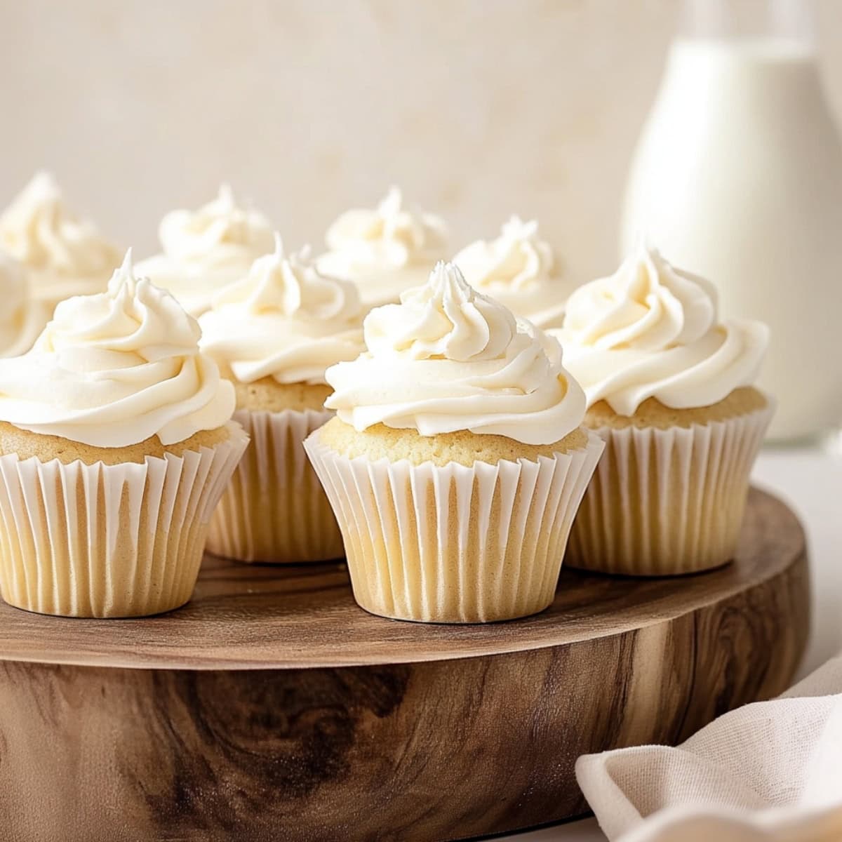 A luxurious white chocolate cupcake with a swirl of frosting on a wooden board.