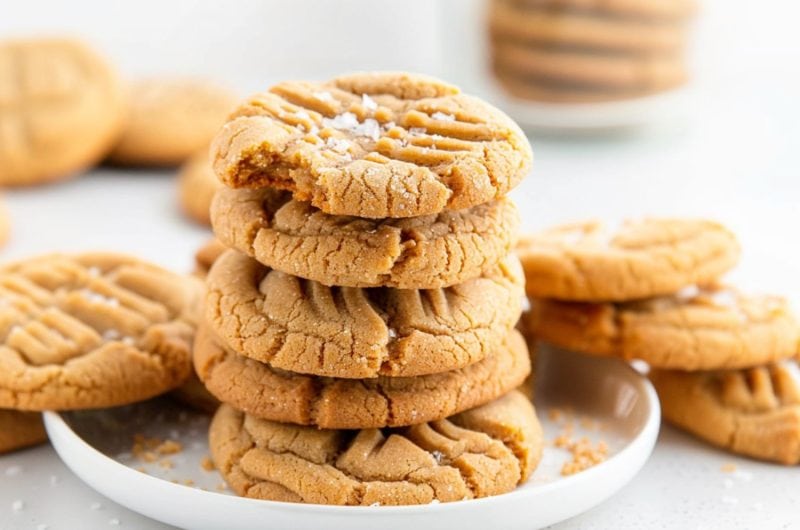 Peanut butter cookie stacked on a white plate.