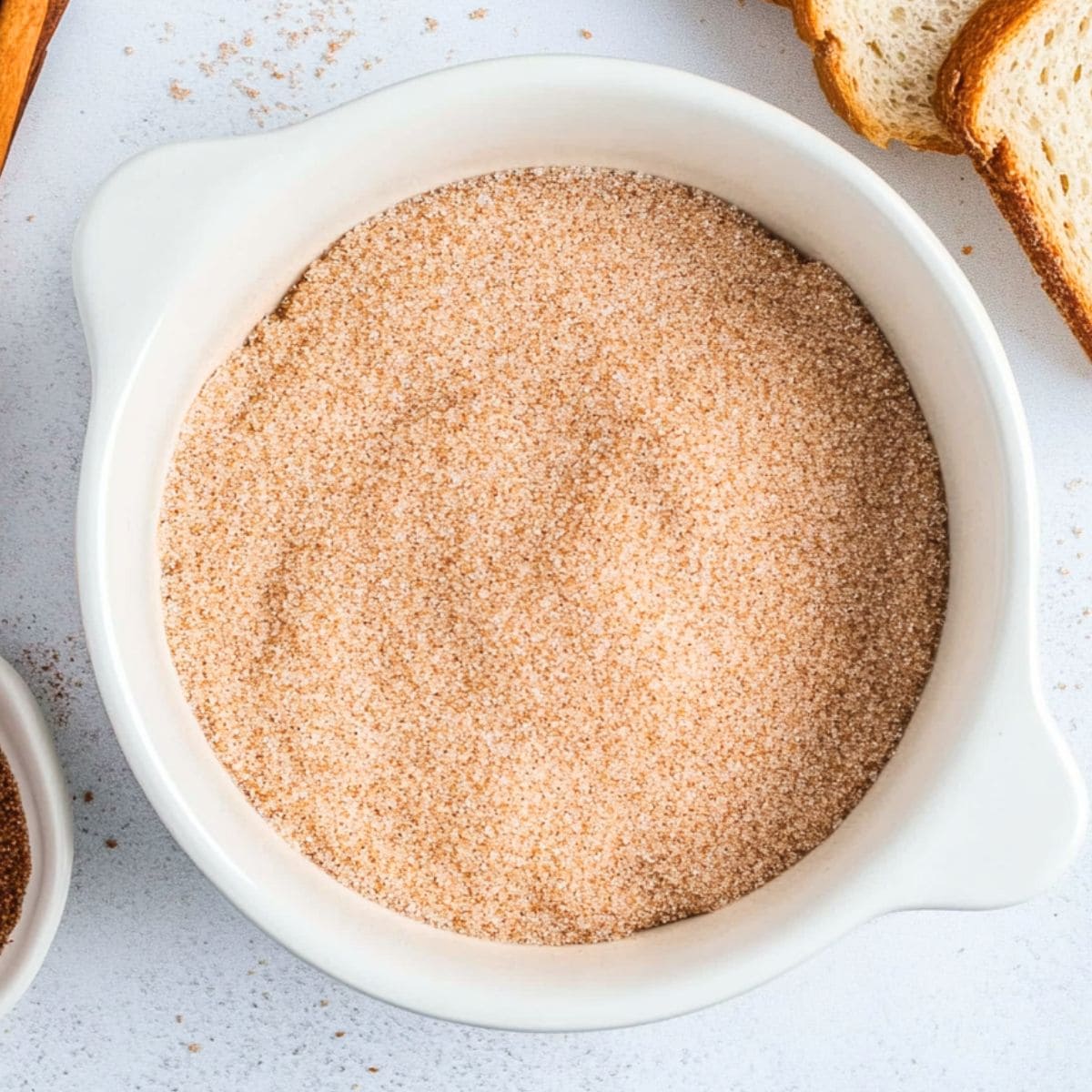 Cinnamon and sugar mix in a white bowl.