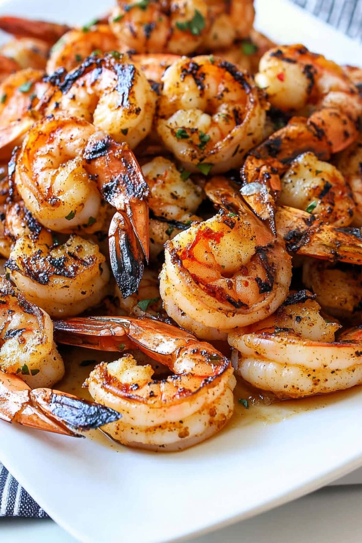 Bunch of grilled shrimp served on a white plate.