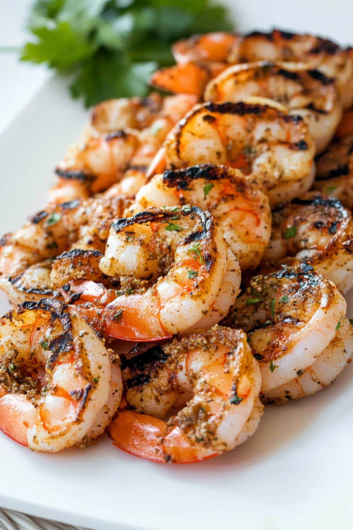 Seasoned grilled shrimp arranged in a white platter. 