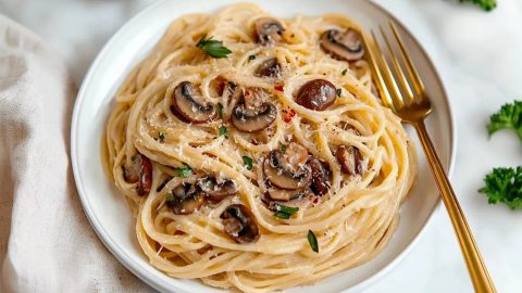 Creamy miso pasta with a rich, smooth sauce and tender mushroom slices, garnished with parmesan and red pepper flakes.