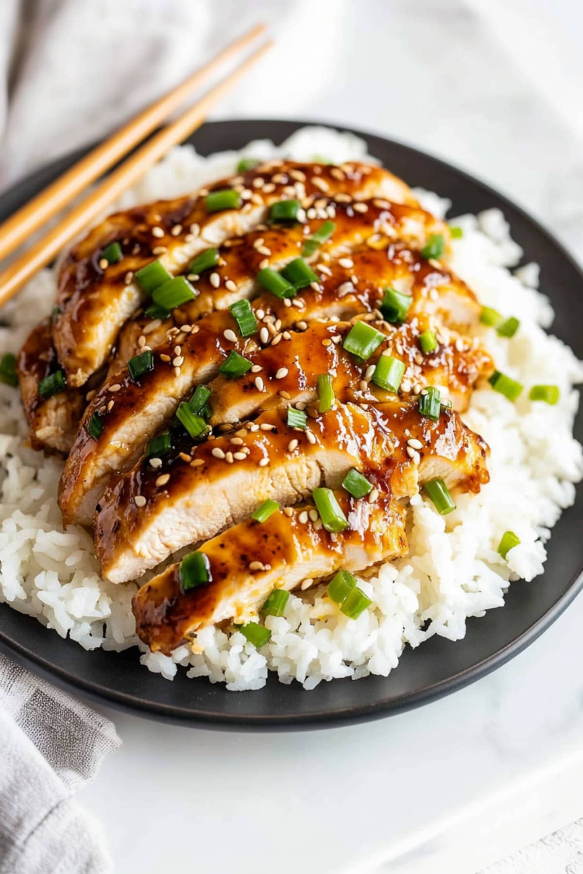 Homemade honey garlic chicken with sesame seeds and chopped green onions.