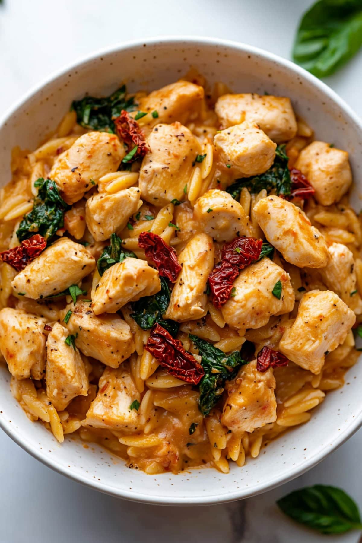 One-pan marry me chicken and orzo with spinach and sun-dried tomatoes in a bowl.