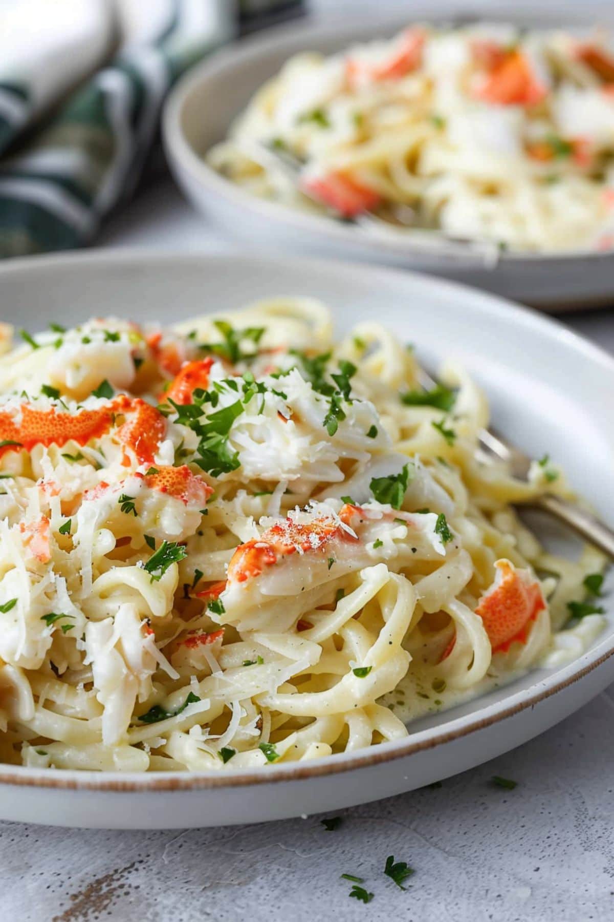 Creamy alfredo with crab meat and Parmesan cheese served in white plates.