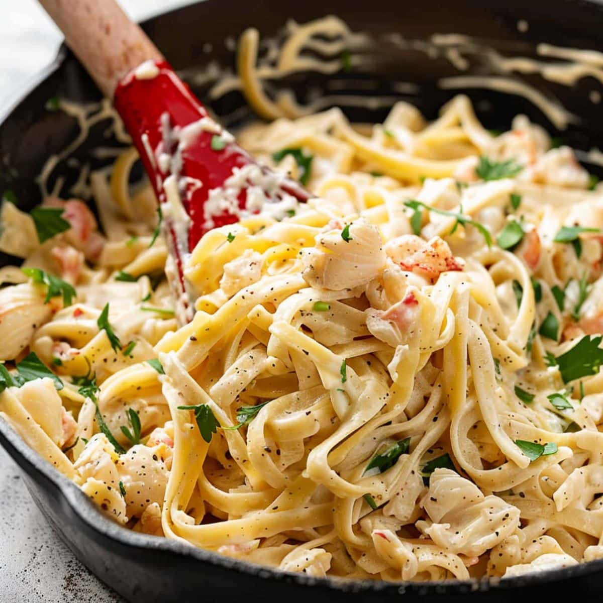 Red Lobster crab alfredo tossed in a skillet pan.