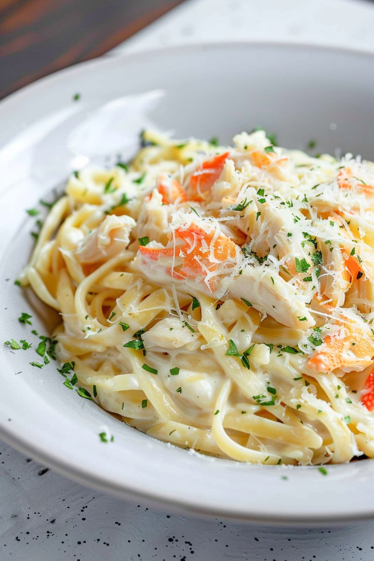 A serving of creamy Red Lobster crab alfredo garnished with chopped parsley and grated Parmesan.