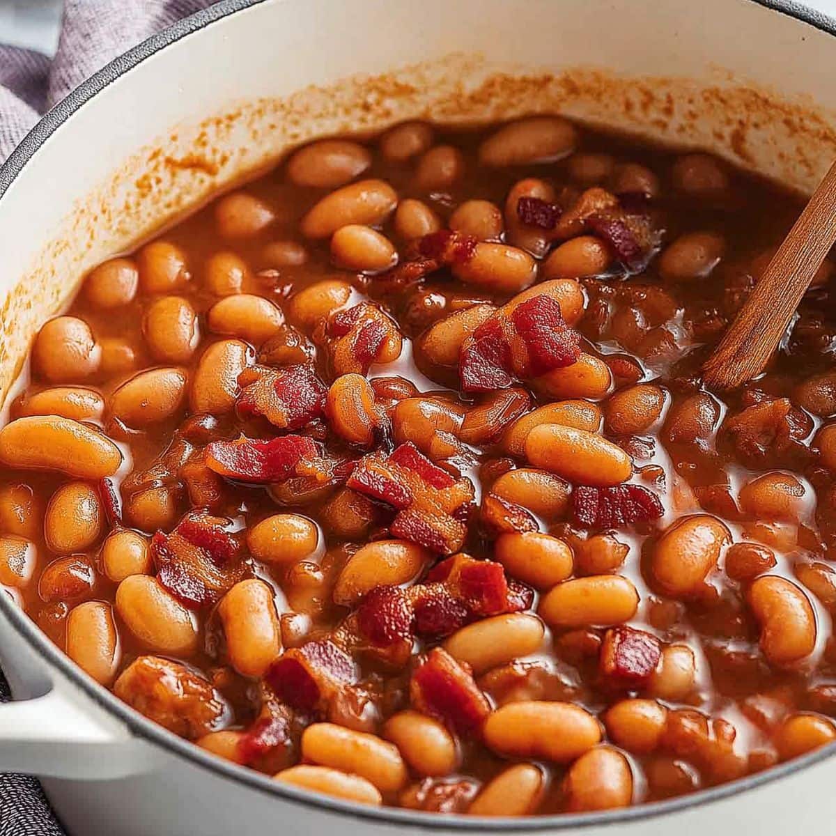 Baked beans with chopped bacon in a Dutch oven pot.