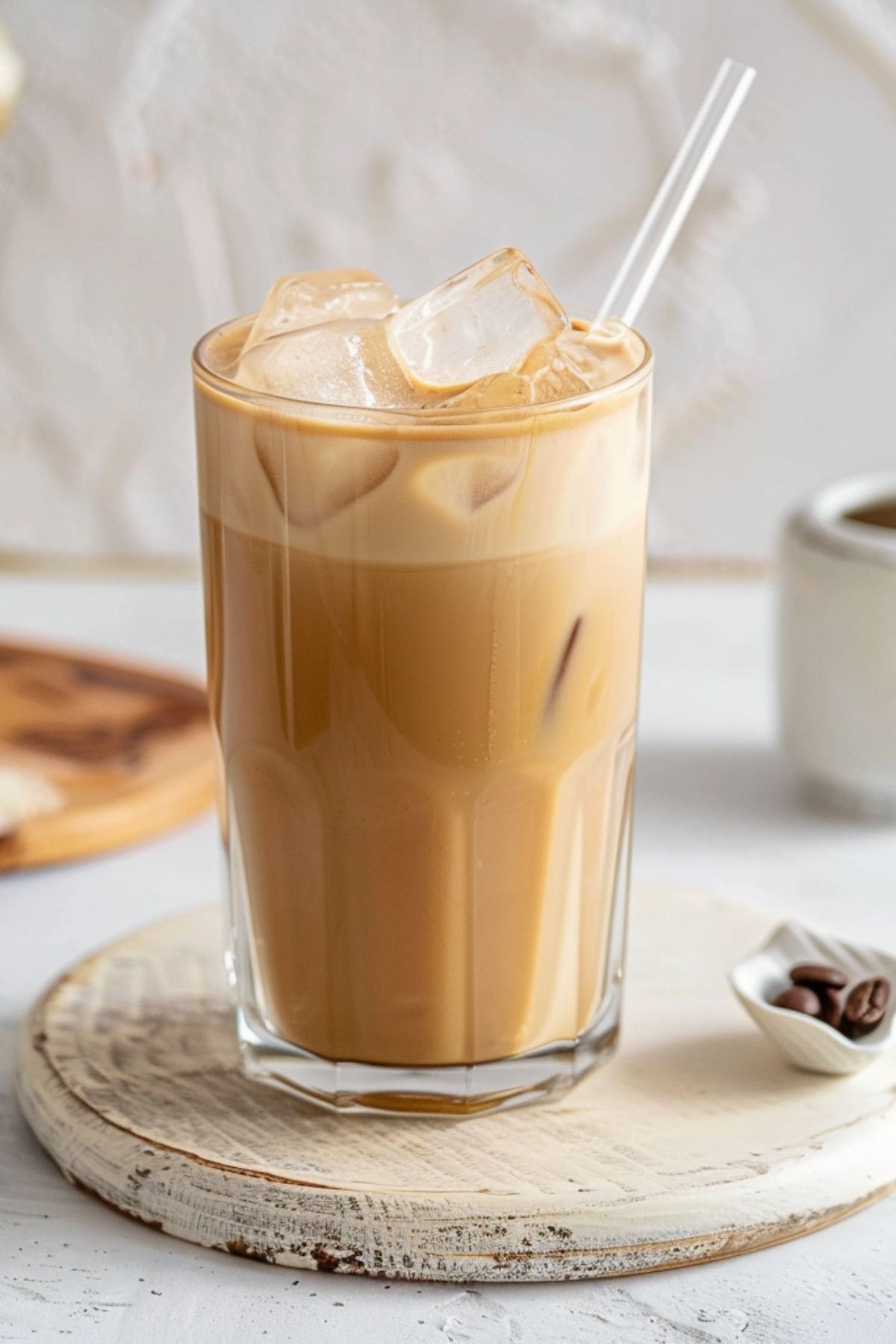 Iced coffee served in glass with straw.