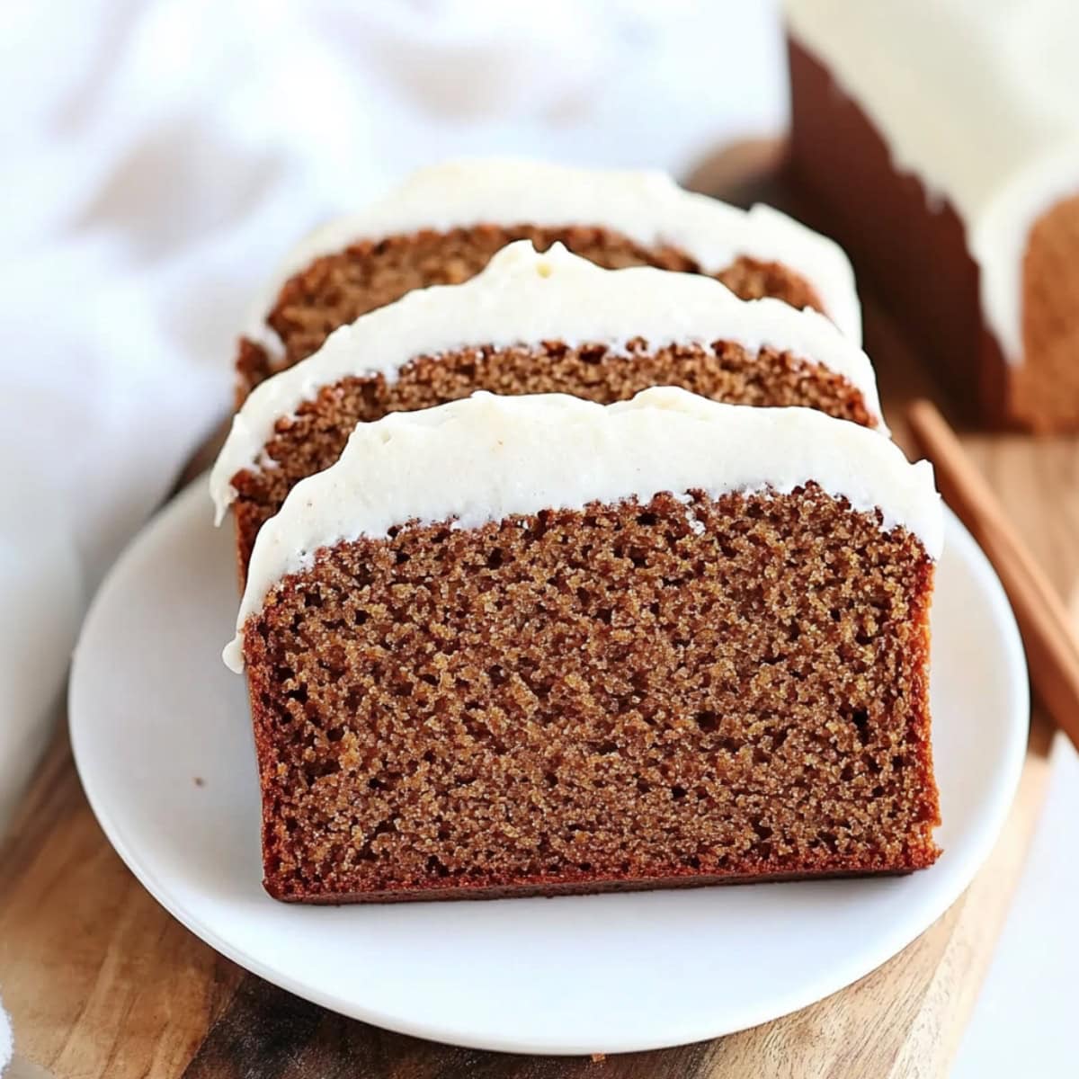 Sliced of gingerbread loaf bread served in a white plate.