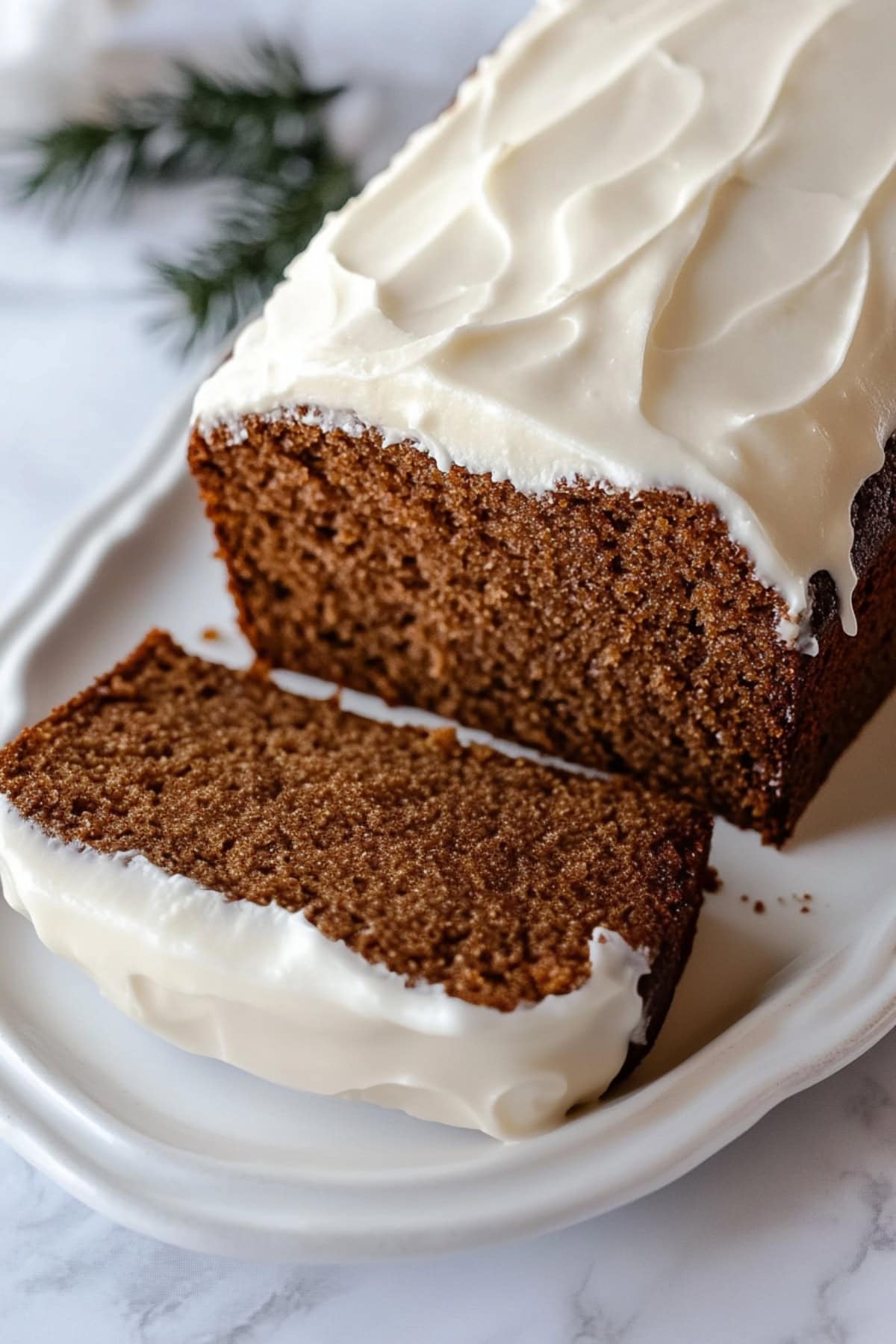 Sliced gingerbread load with spread of cream frosting on top.