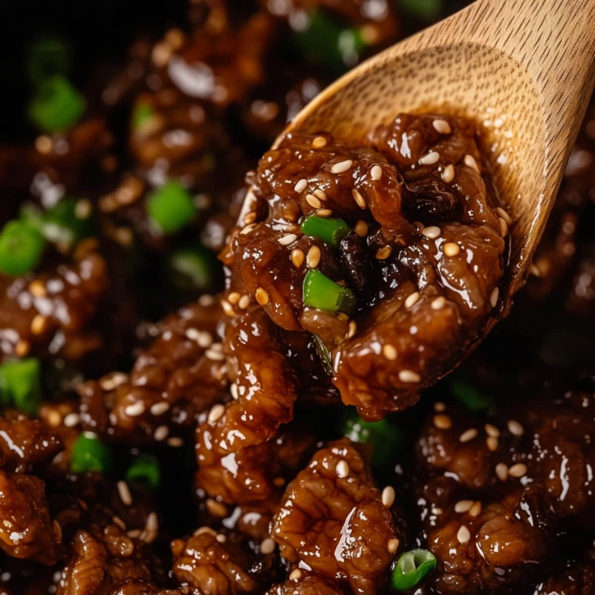 Beef teriyaki tossed by a wooden spoon ladle