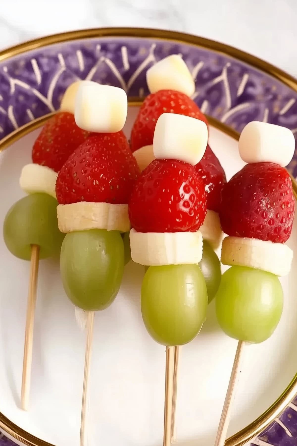 Fruit skewers with strawberries, grapes, marshmallows and banana slices.