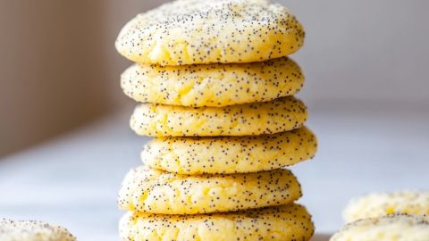 Close-up of golden-brown lemon poppy seed cookies on a white marble table