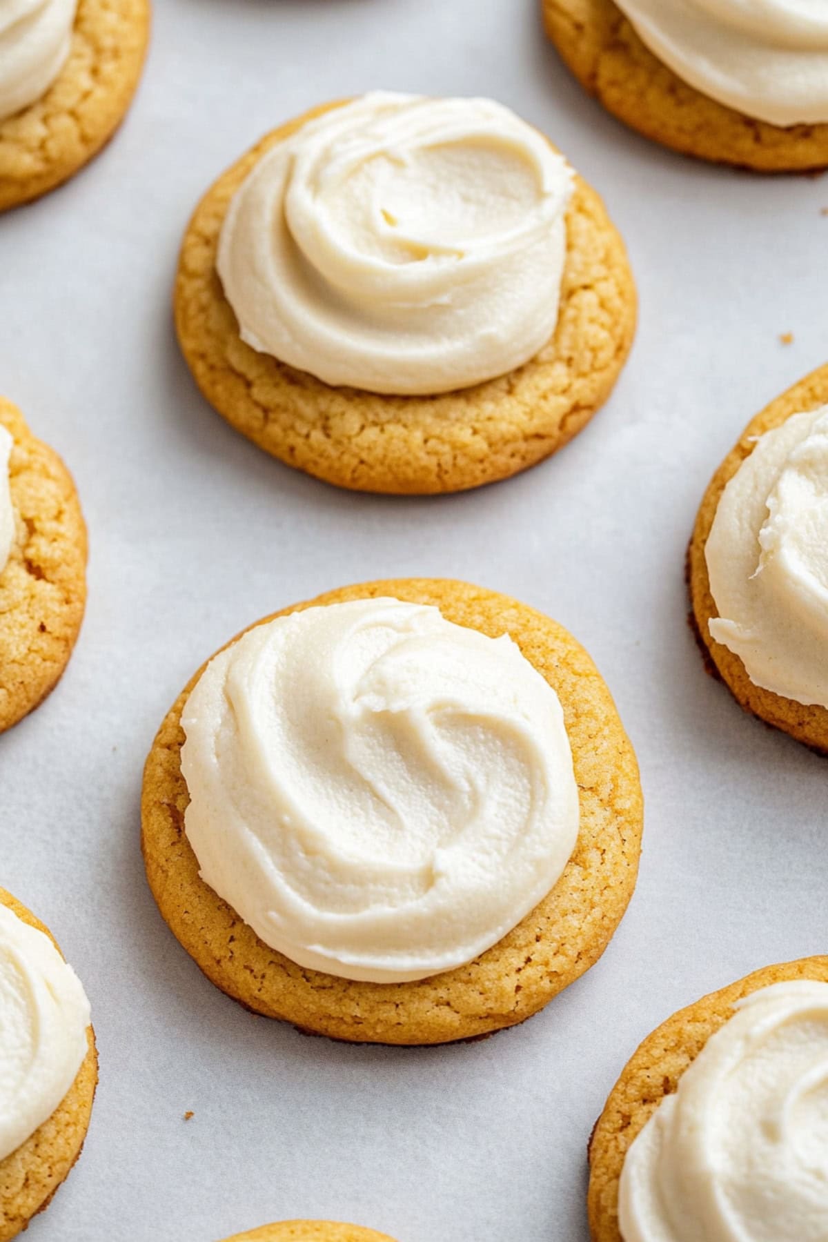 An overhead view of pumpkin cake mix cookies topped with cream cheese frosting.