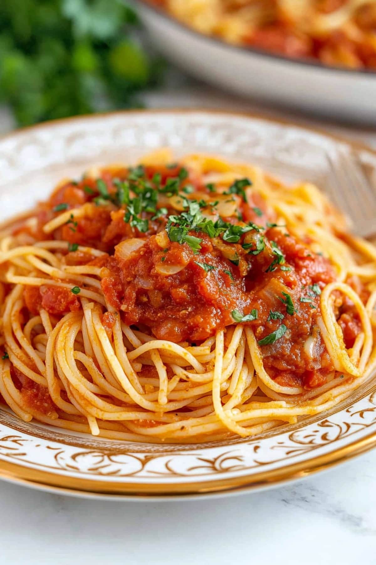 Spaghetti arrabniattia served in a plate garnished with chopped parsley on top.