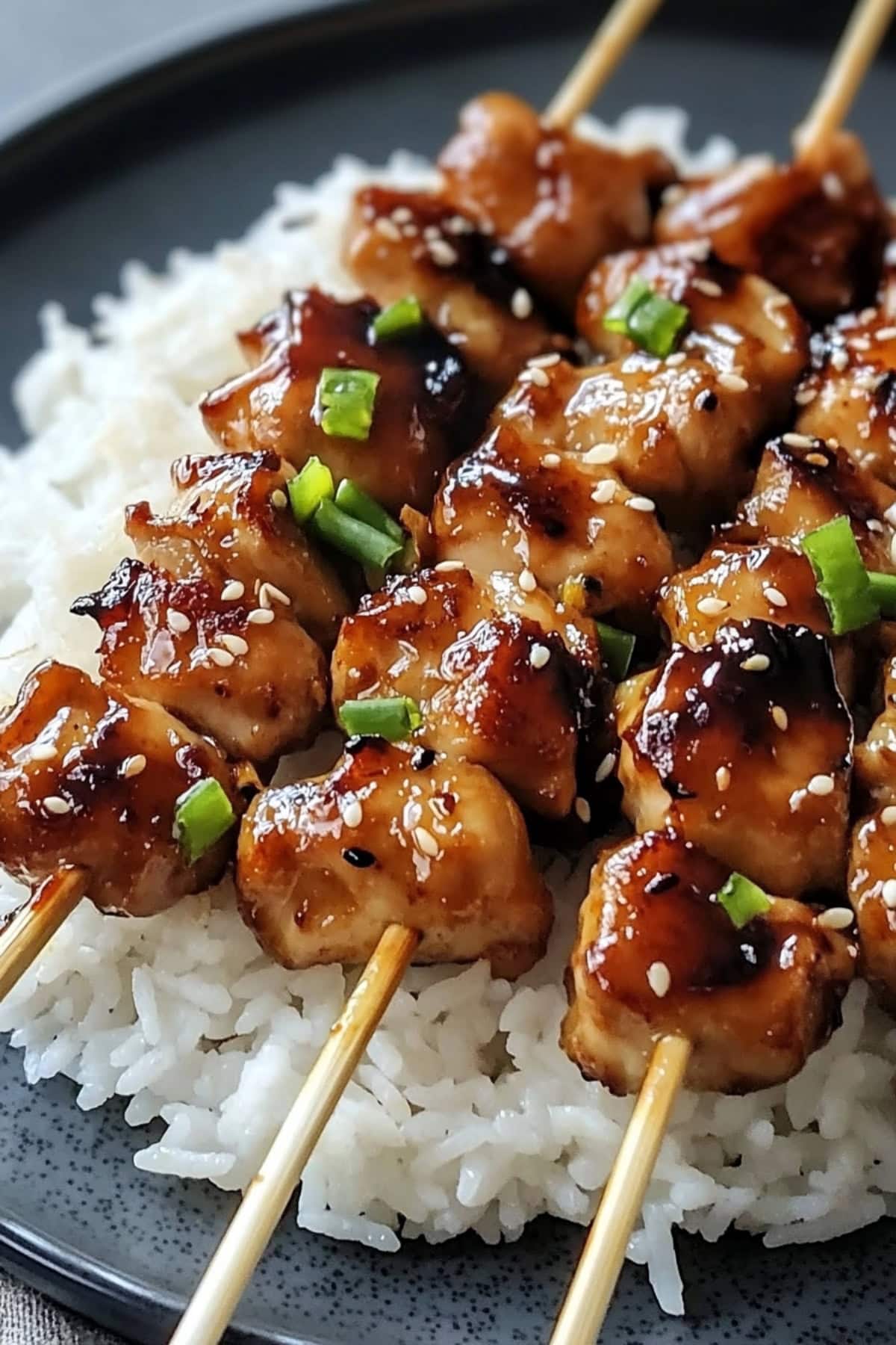 Homemade teriyaki chicken sewers with sesame seeds and chopped green onions, served with rice. Close up