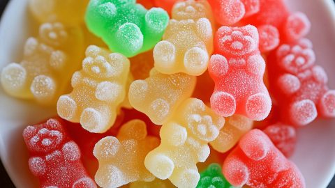 An overhead view of colorful gummy bears in a white plate.