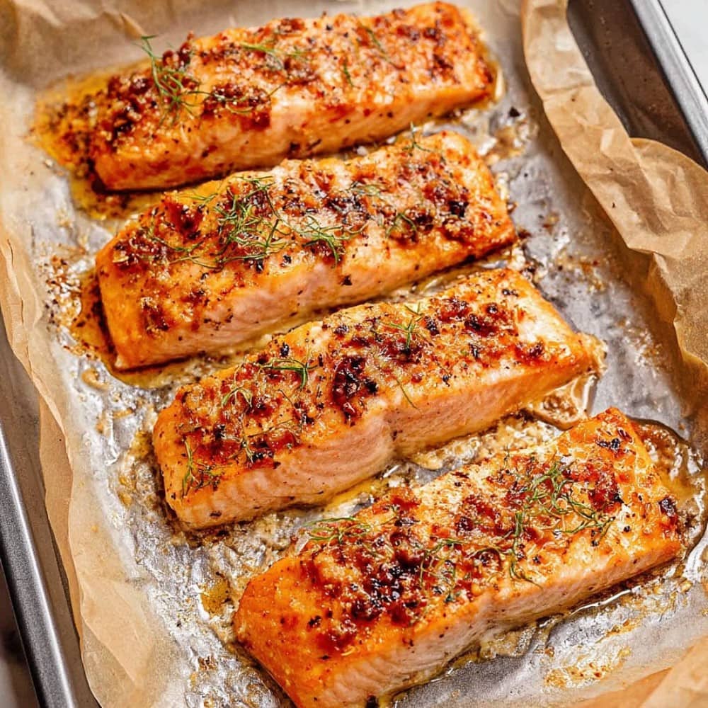 Baked Honey Dijon Salmon fillets on a baking pan, overhead view.