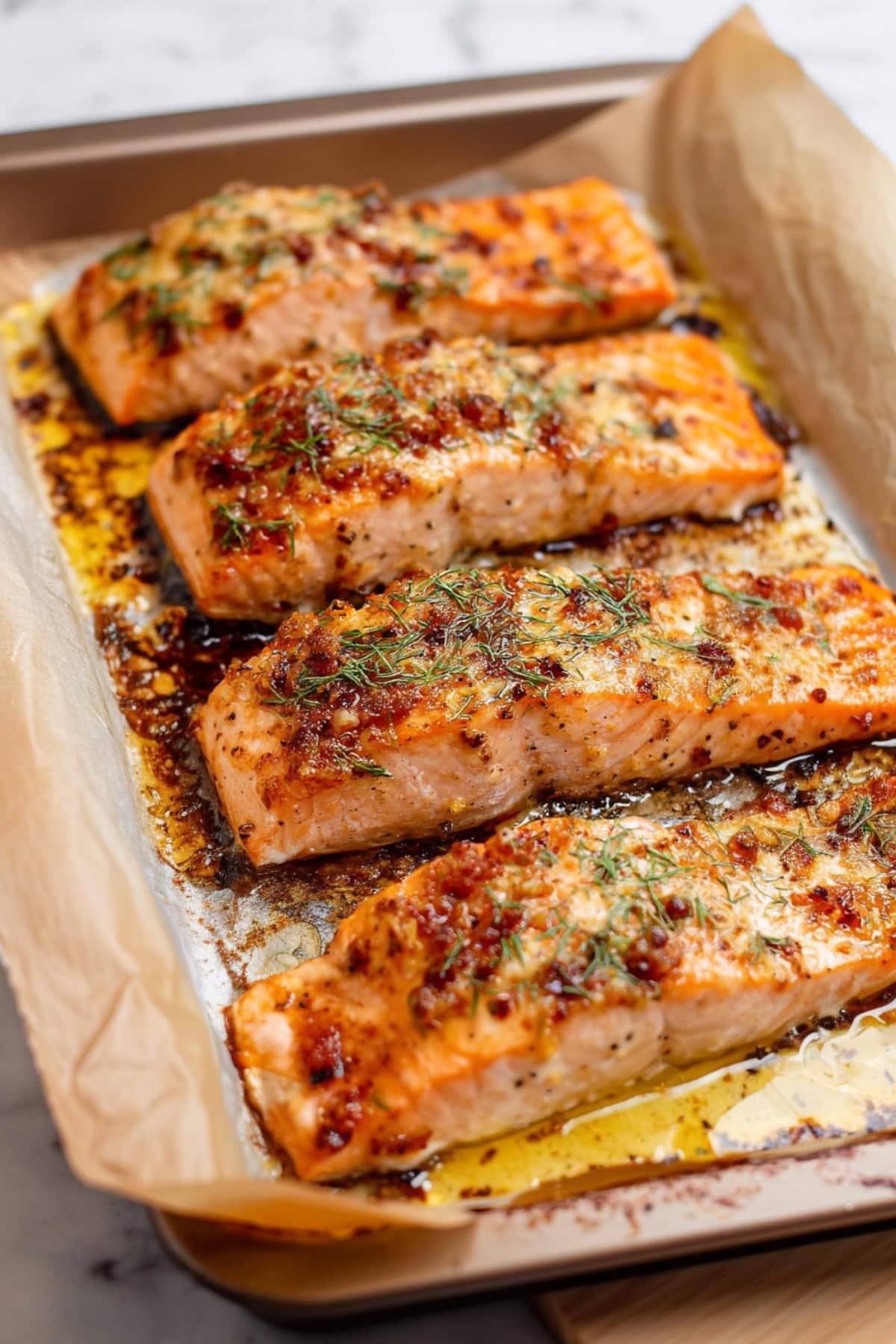 Baked Dijon Salmon fillets on a baking pan.