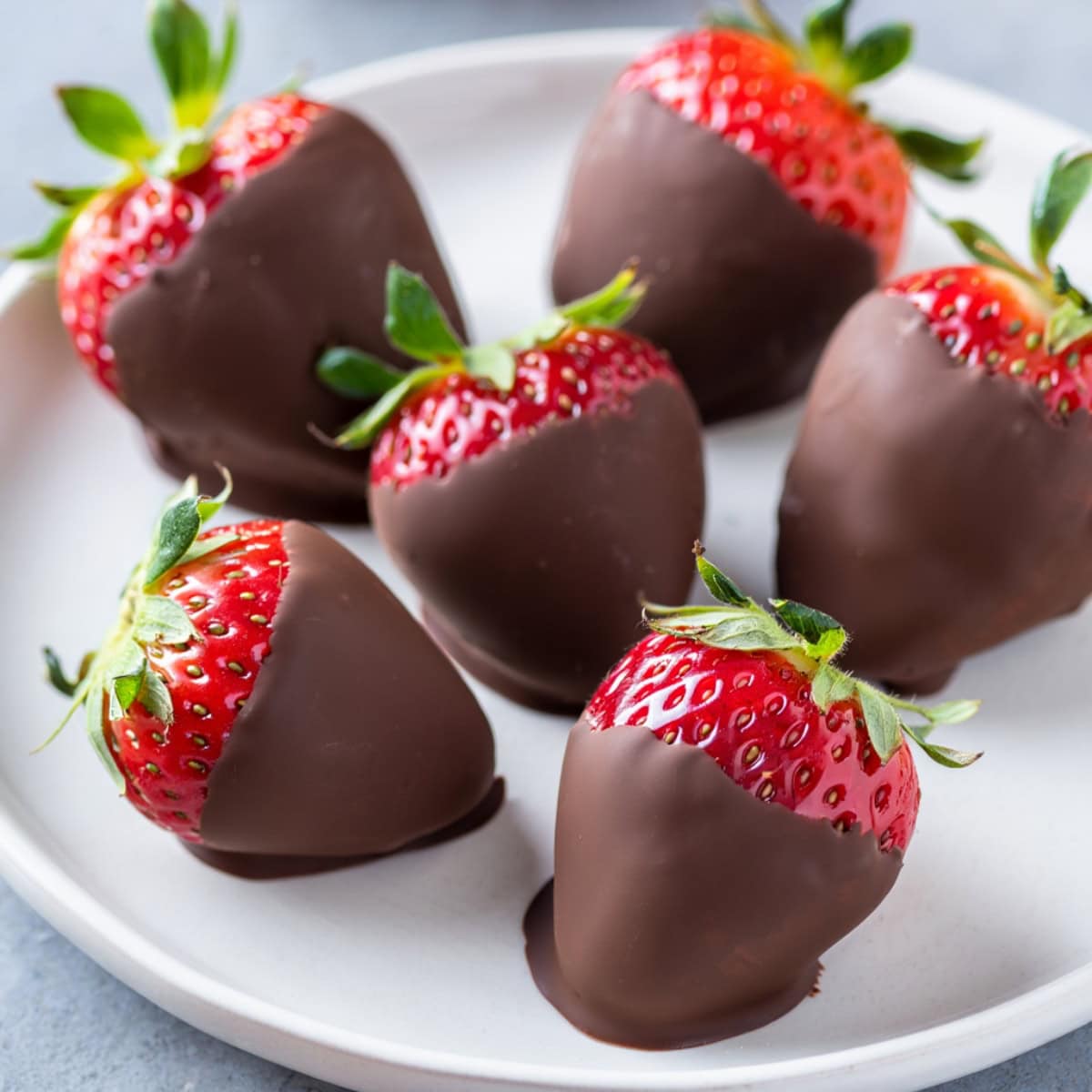 Chocolate dipped strawberries in a white plate.