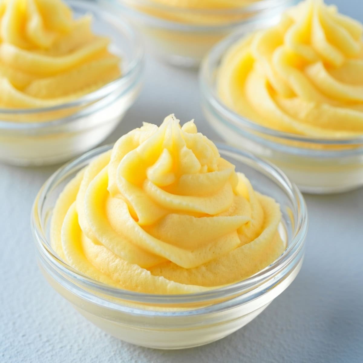 Pineapple whip in a swirling pattern in glass containers.