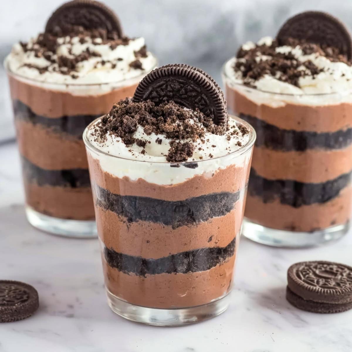 Pudding cups with crushed oreo cookes, topped with whipped cream.